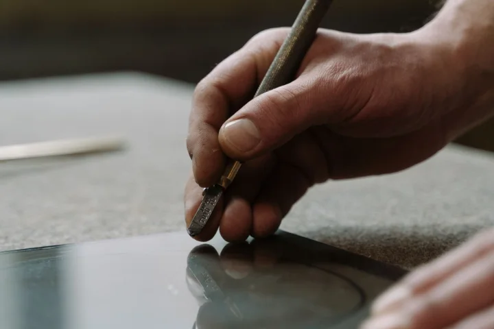 Vitrier découpant une plaque de verre en atelier